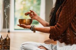 Frauenhand mit Klangschale in Meditationshaltung